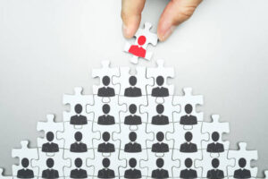 Assembling jigsaw puzzle. Organizing business people hierarchy.